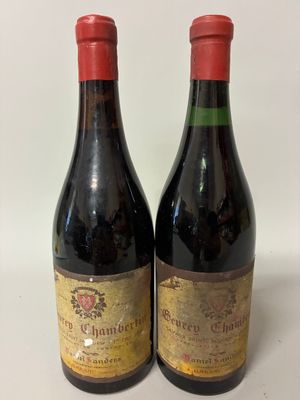 two bottles of red wine sitting on top of a white table