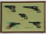 a picture of a display of guns in a wooden frame