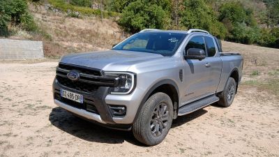 un camion argenté garé sur un terrain en terre battue