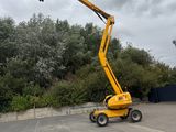 un homme qui se trouve dans un ascenseur jaune sur le parking