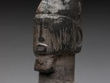 a close up of a wooden sculpture of a person wearing a hat