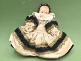 a doll of a woman in a dress on a green surface