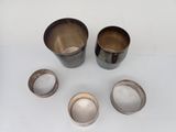 three cups and a spoon are sitting on a table