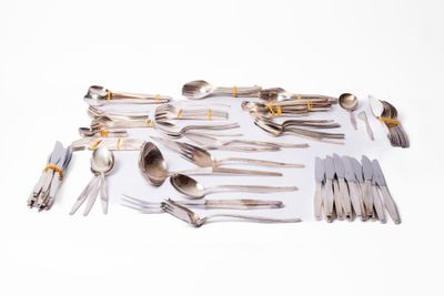 a lot of silver spoons and forks on the table