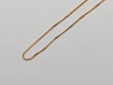 un collier en or auquel est attachée une chaîne