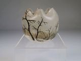 un vase blanc orné d'un arbre, posé sur un socle transparent