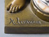 a bronze statue of a woman with her feet on a marble base