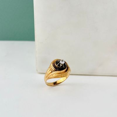 a close up of a gold ring with a black stone in the center