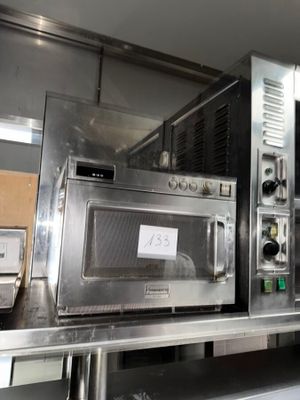 a silver microwave sitting on top of a metal counter