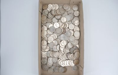 une boîte remplie de pièces d'argent posée sur une table