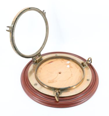 une plaque en bois et en laiton surmontée d'un miroir