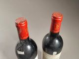 two bottles of wine sitting next to each other on a table