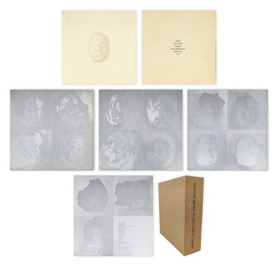 un ensemble de photographies et une boîte de papiers posés sur une surface blanche