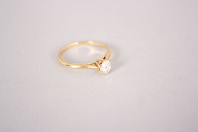 a gold ring with a single diamond on top of it