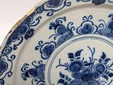 a blue and white plate with a flower design on it