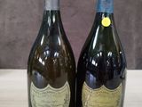 deux bouteilles de champagne posées sur une table l'une à côté de l'autre
