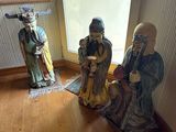 trois figurines assises dans un coin d'une pièce