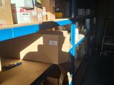 boxes are stacked on a shelf in a warehouse with a ladder in the background