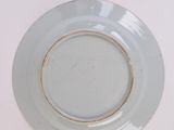 a white plate with a gold rim sitting on a table