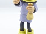 figurine of a man with a toothbrush in his mouth next to a coin