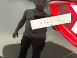 a man standing next to a car holding a sign