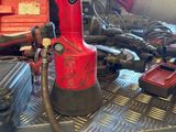 a red drill that is sitting on top of a table