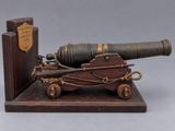 an old cannon on a wooden stand with a book in the background