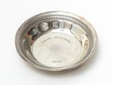 a silver plate with a picture on it on a white surface