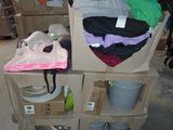 a cart full of clothes and other items in a warehouse