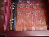 a red case with a bunch of coins inside of it