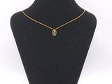 a black mannequin with a gold necklace on it
