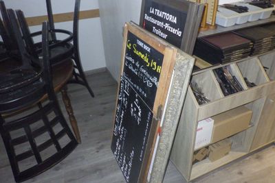 un tableau noir sur lequel est inscrit un menu, à côté d'une chaise