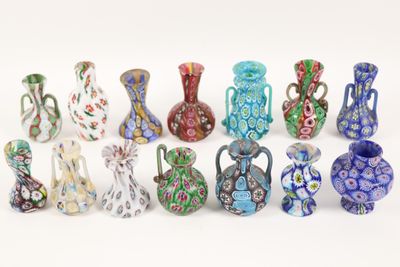 many different colored vases sitting on a white surface