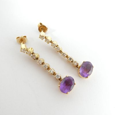 une photo d'une paire de boucles d'oreilles en améthore et en diamant