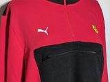a close up of a red and black sweatshirt with a puma logo on the chest