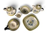four pieces of tea set on a white surface
