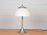 une photo d'une lampe de table posée sur une surface en bois, sur fond blanc