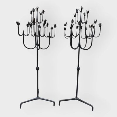 une paire de chandeliers en fer noir ornés de fleurs