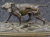 bronze statue of a dog with a duck in its mouth on a base