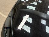 a sticker on the windshield of a car that is parked in a parking lot
