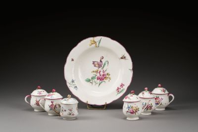 une assiette blanche ornée de fleurs roses, posée à côté d'une tasse et d'une soucoupe