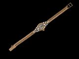 une montre-bracelet en or sertie de diamants sur fond noir