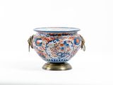 un vase bleu et rouge posé sur un socle