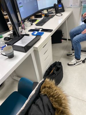 un homme assis sur une chaise devant un bureau équipé d'un ordinateur