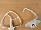 a white mixer attachment and a white mixer attachment on a wooden table