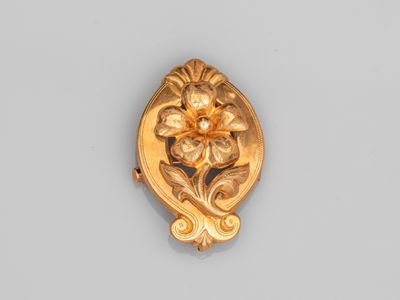une image représentant une broche en or ornée d'une fleur