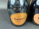 two bottles of champagne sitting next to each other on a table