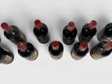 several bottles of wine are lined up in a row on a white surface