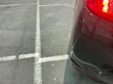 a close up of a red car parked in a parking lot