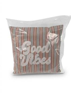 L'oreiller est dans un sac en plastique transparent sur lequel est inscrit « Good Vibe ».